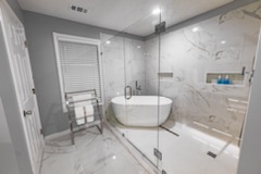 Modern bathroom with freestanding tub and marble-look tile