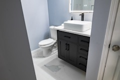 Modern bathroom vanity with dark cabinet and white countertop
