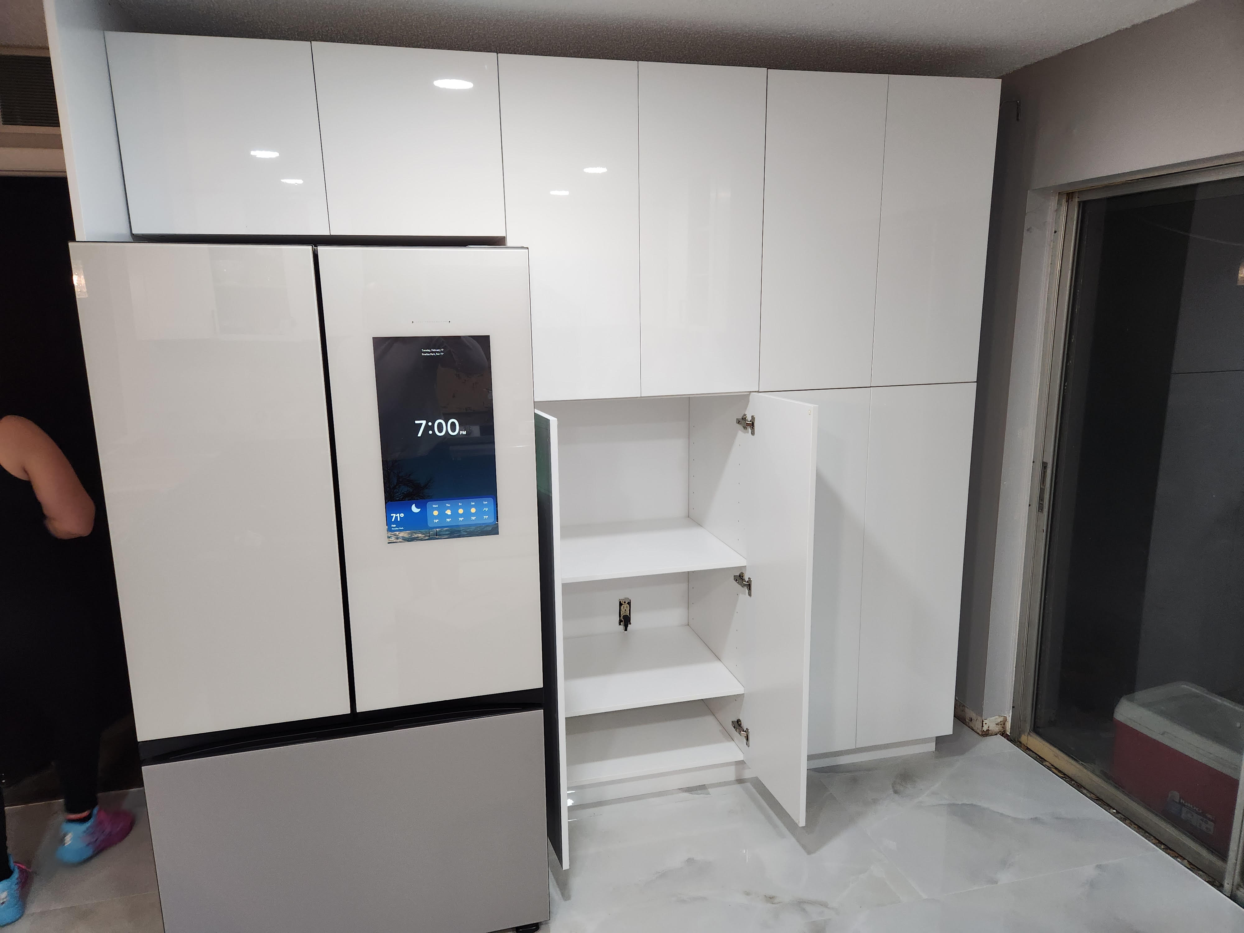Gloss white cabinet wall beside refrigerator